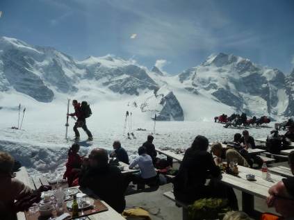 Walkers, tourists and sunbathers at the Diavolezza mountain restaurant looking towards Piz Bernina